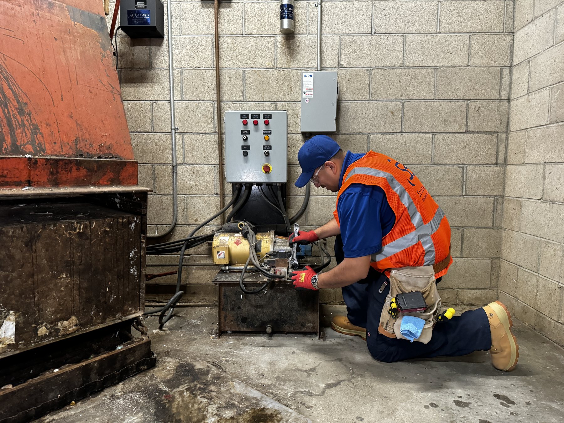 Strategic technician maintaining chute and compactor equipment at Reata Apartments