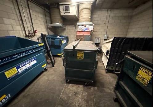 Collection bins and items at the chute opening in the trash room at Reata Oakbrook Village Apts before service