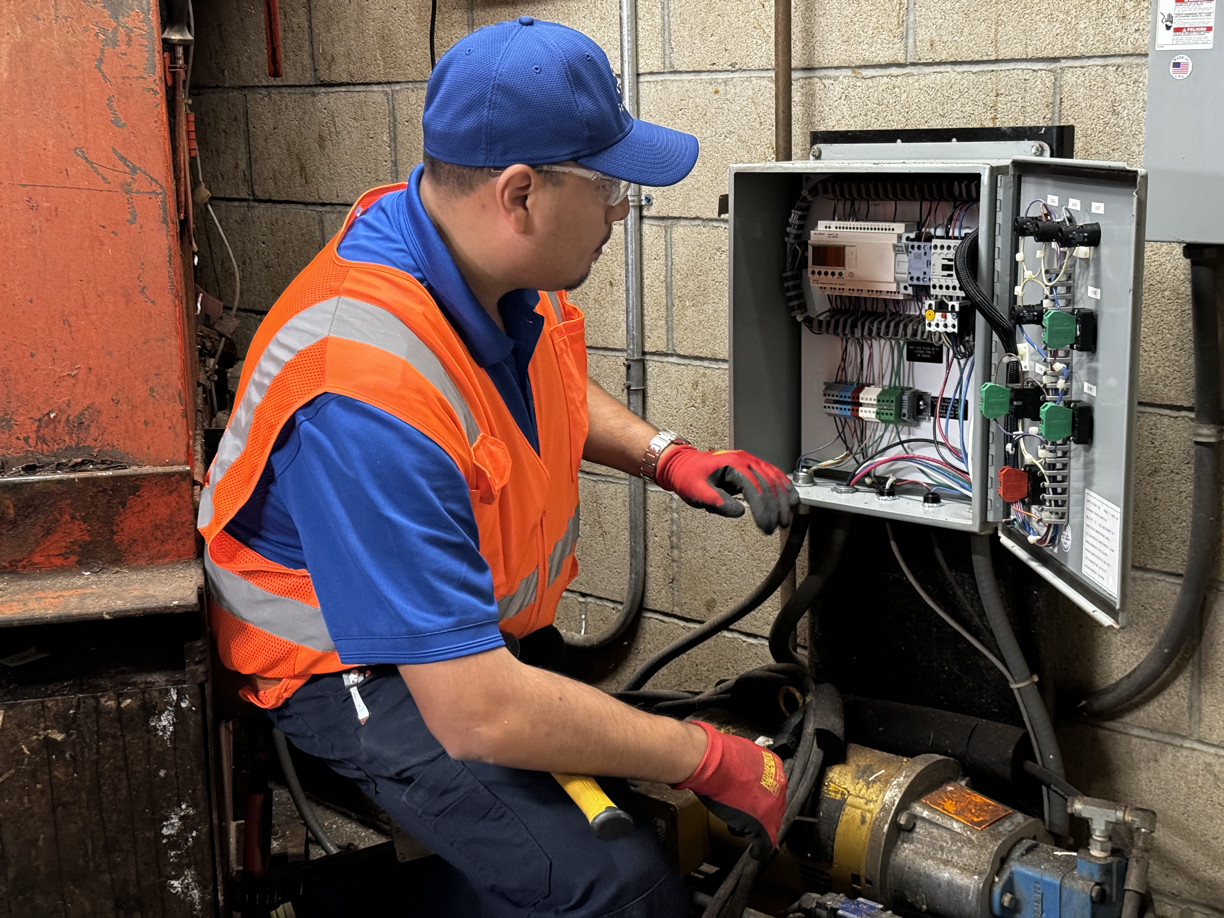 Strategic technician inspecting an open compactor control panel
